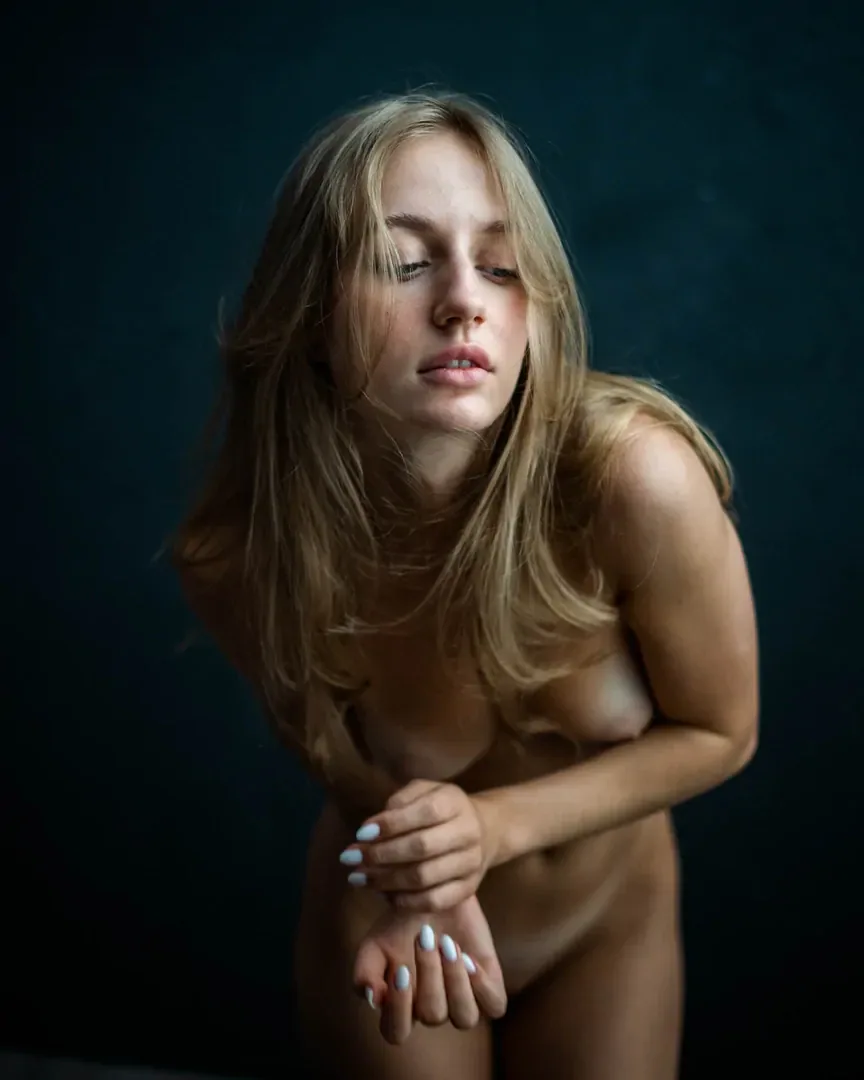 Nude portrait of a woman against a blue background