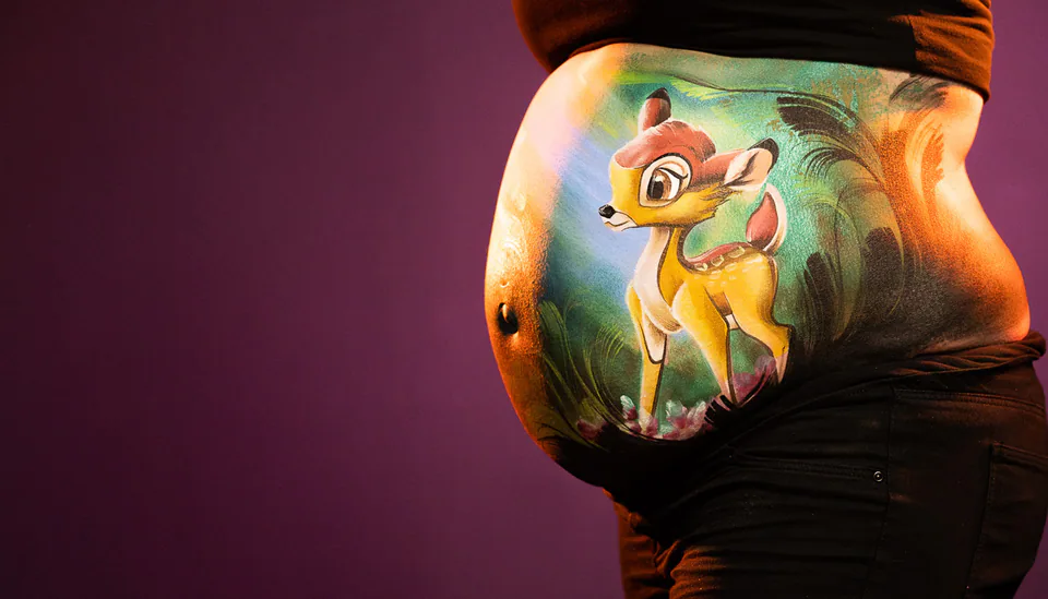 Babybauch mit gemaltem Rehmotiv im normalen Licht