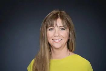 Smiling woman with long brown hair and a bright yellow top