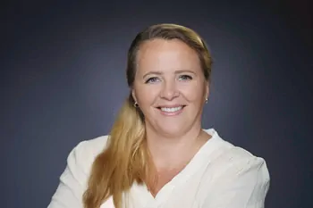 Smiling woman with a long side braid and a white top