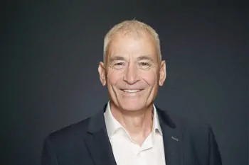 Smiling man with short grey hair, a dark jacket and a white shirt