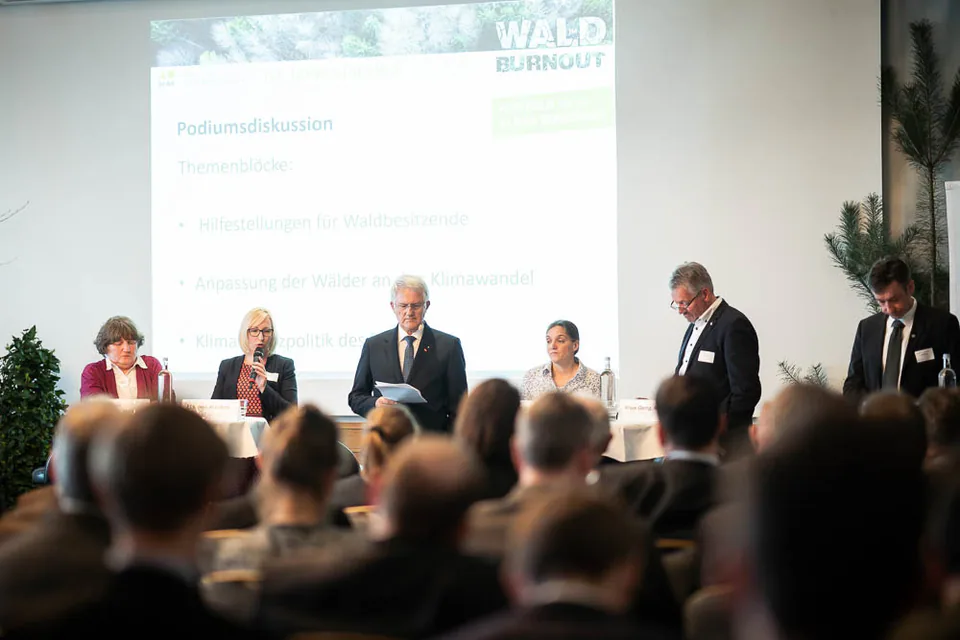 Mehrere Personen bei einer Podiumsdiskussion vor Publikum