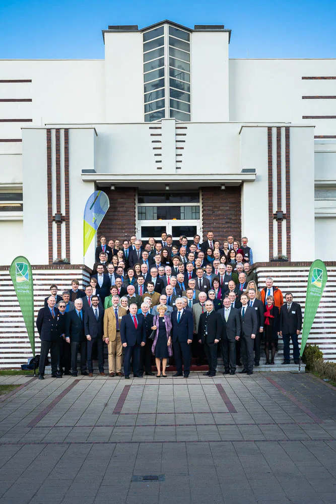 A large group posing for a portrait in front of a building