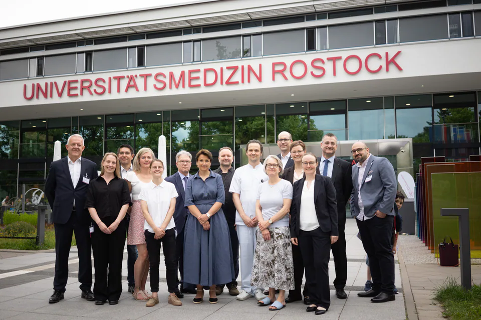 A large group posing for a portrait in front of a building