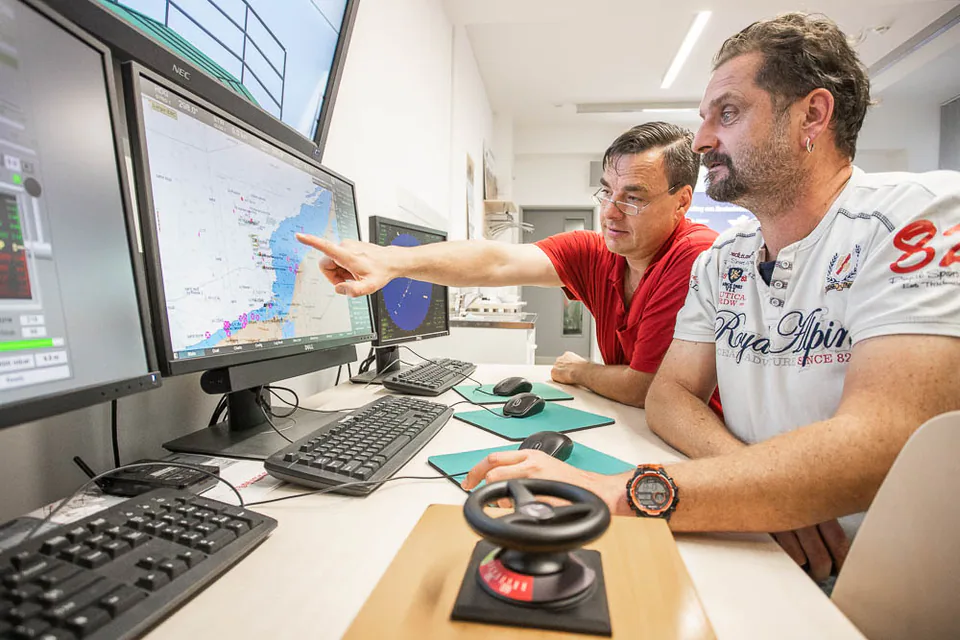 Zwei Männer arbeiten an Monitoren in einer Leitstelle