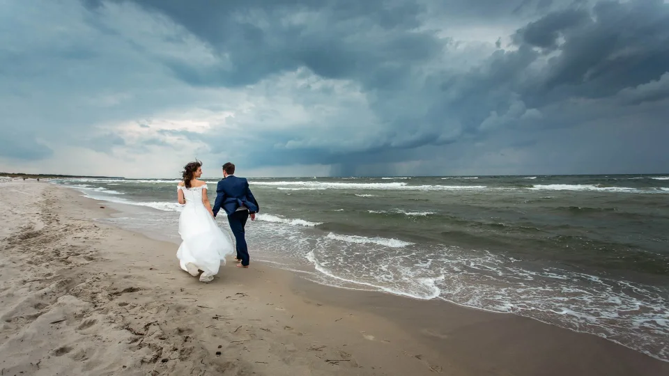 Wedding couple in stormy weather on the beach in Ahrenshoop