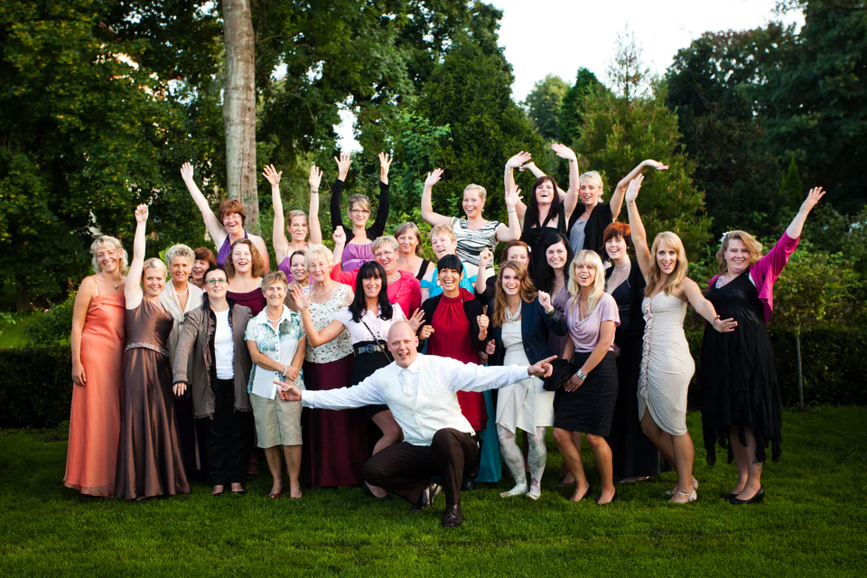 Gruppe von Frauen winkt im Garten, ein Mann steht im Vordergrund