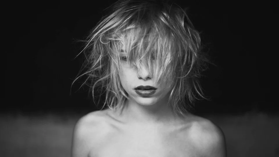 Schwarz-Weiß-Portrait einer blonden Frau mit bewegtem Haar