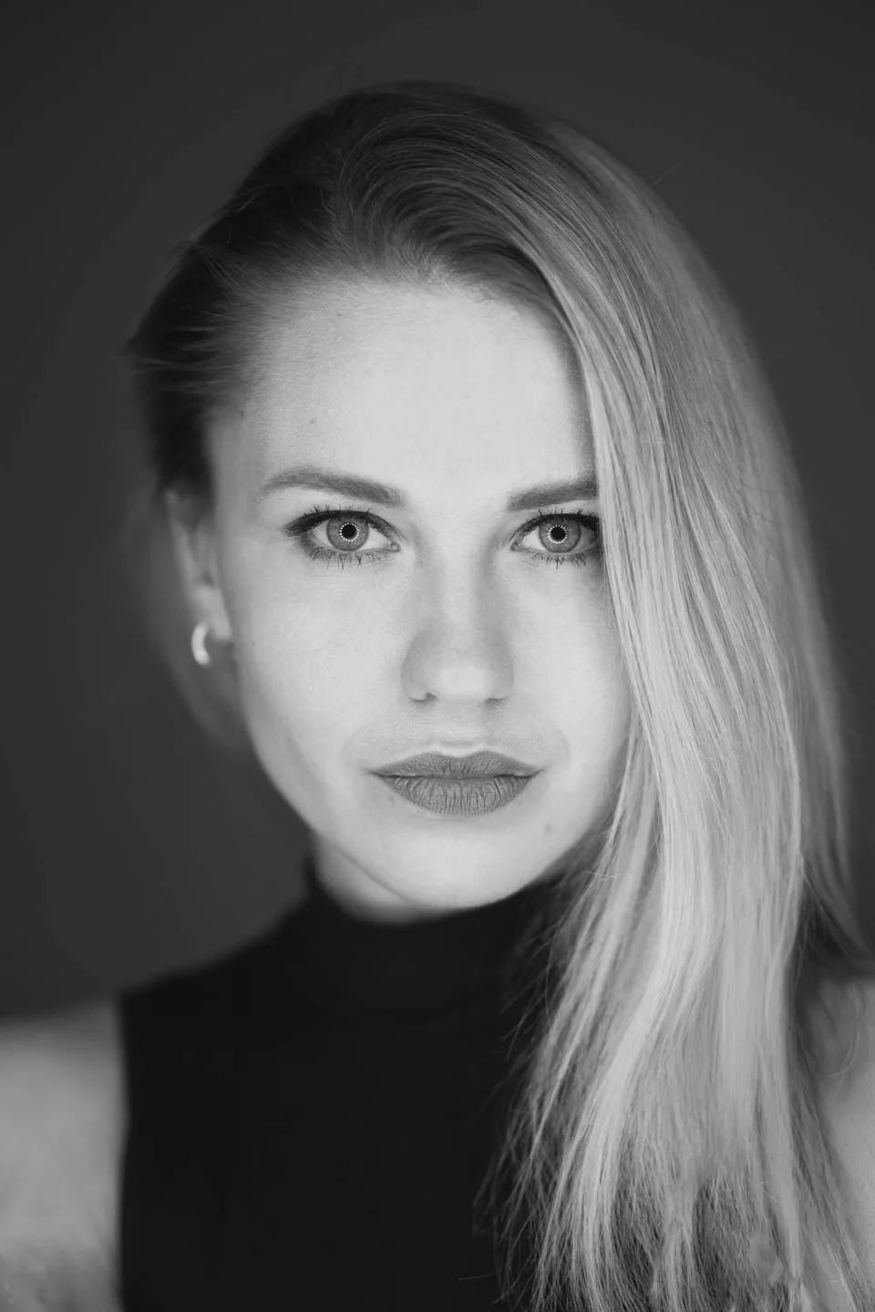 Nahes Schwarz-Weiß-Portrait einer blonden Frau mit direktem Blick im Fotostudio Rostock