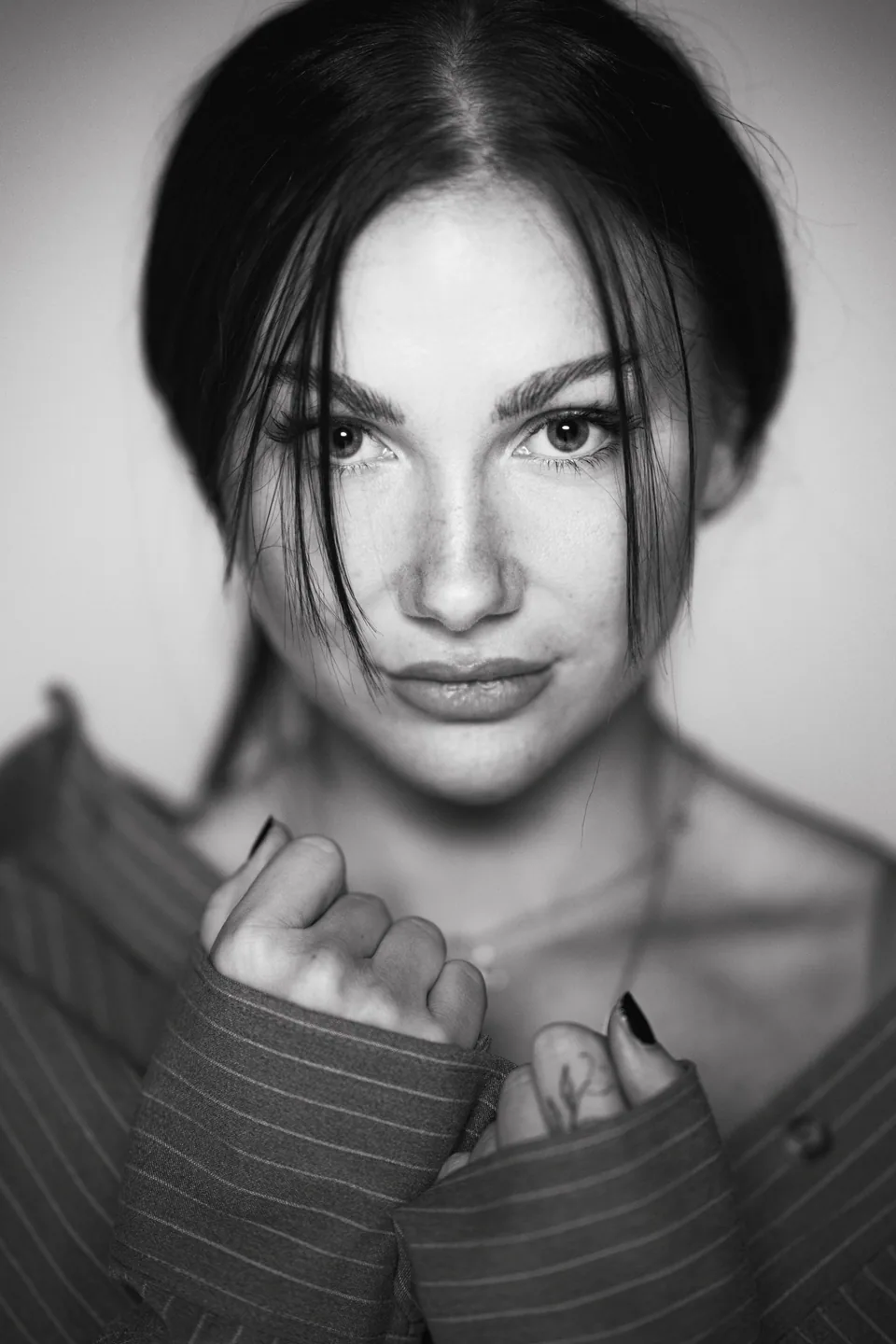 Schwarz-Weiß-Portrait einer Frau mit dunklem Haar und gestreiftem Hemd