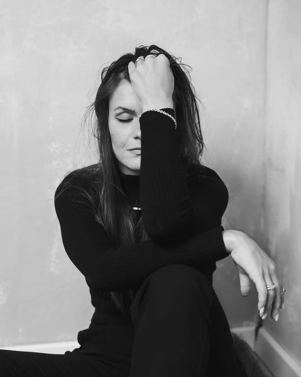 Schwarz-Weiß-Portrait einer sitzenden Frau mit schwarzem Pullover