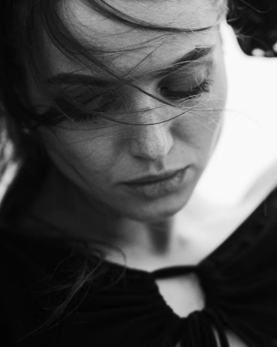 Schwarz-Weiß-Portrait einer Frau mit vom Wind bewegtem Haar