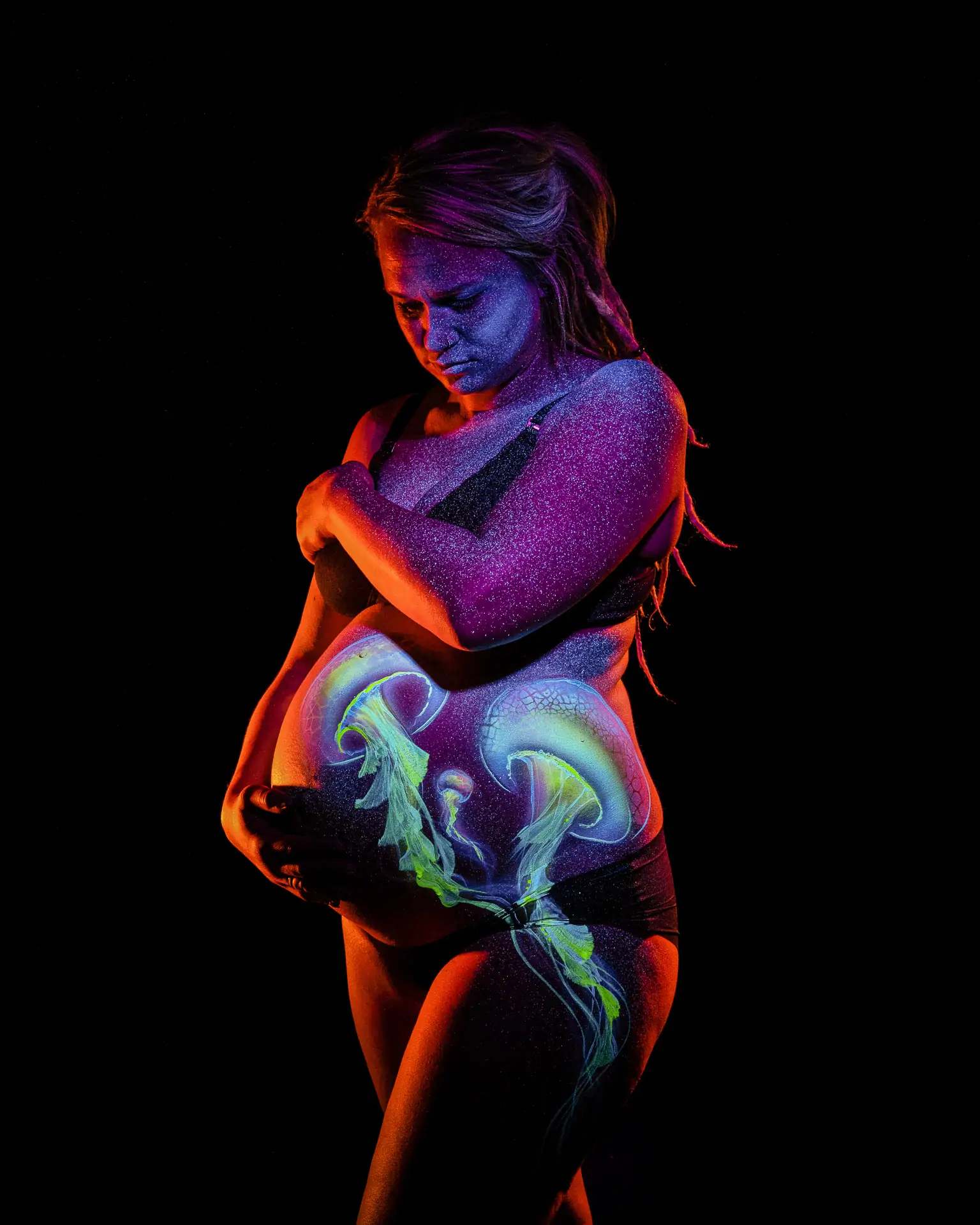 Babybauch mit UV Bodypainting und leuchtenden Farbdetails