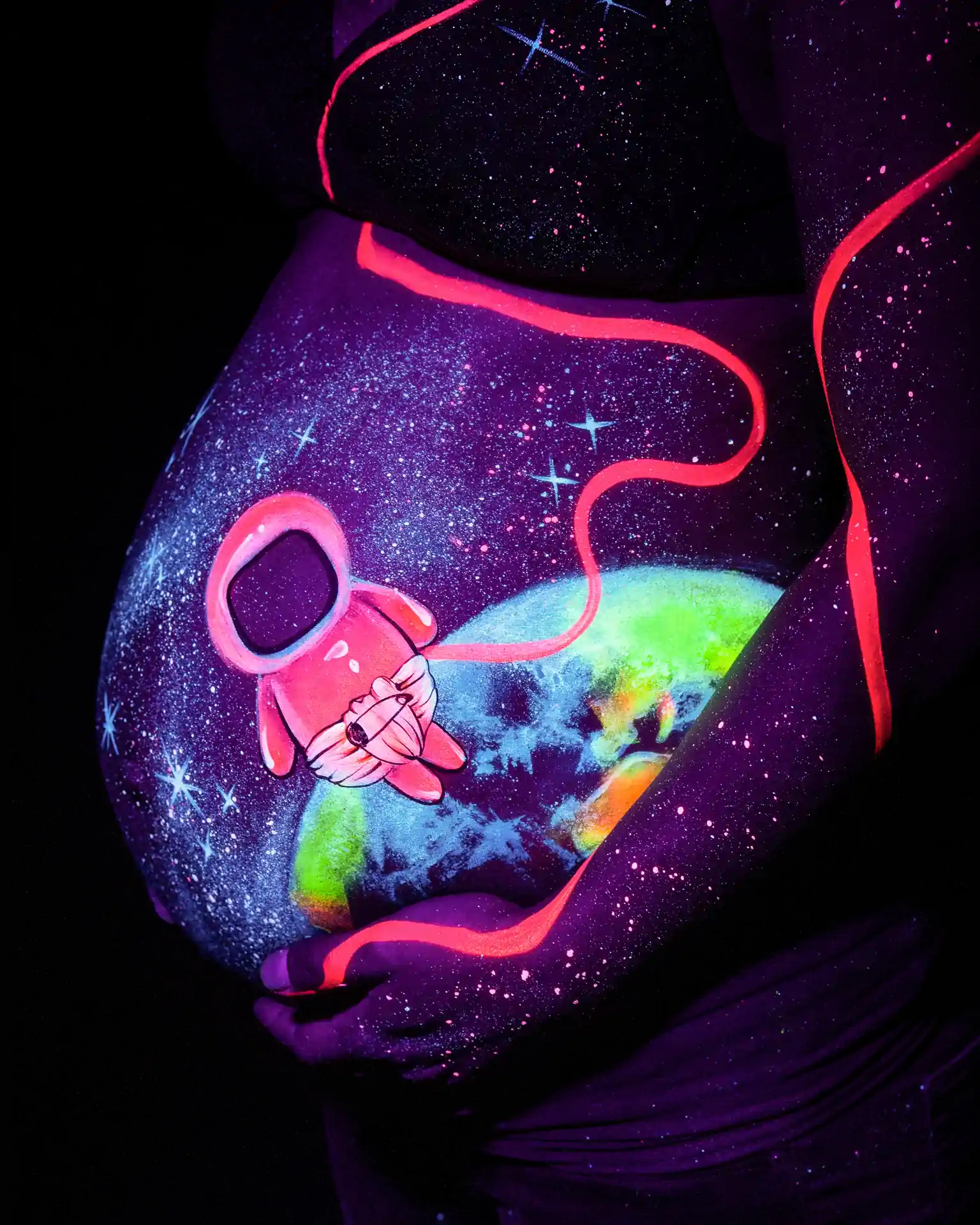 Babybauch Portrait mit leuchtendem Bodypainting im Schwarzlicht